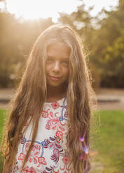 Cute girl standing at public park during sunset - AJOF00598