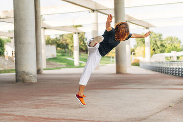 Acrobat practicing jump while exercising at park - ABAYF00022