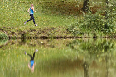 Reflexion einer jungen Sportlerin beim Joggen im Wald - STSF02654