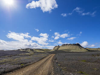 Schotterstraße in Richtung Berg gegen blauen Himmel, Lakagigar, Island - LAF02530