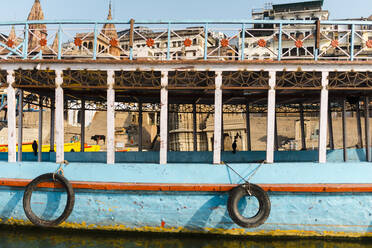 Indien, Uttar Pradesh, Varanasi, Altes Ausflugsboot vor den Gebäuden der Stadt festgemacht - JMPF00603