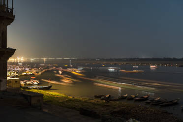 India, Uttar Pradesh, Varanasi, Long exposure of boats sailing along river Ganges at night - JMPF00607