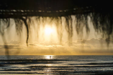 Entfernte Ansicht der Silhouette Frau Paddleboarding auf dem Meer bei Sonnenaufgang - EGAF01048