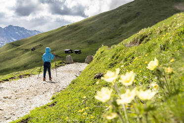 Niedliches männliches Kind mit Wanderstöcken auf dem Wanderweg um die Langkofelgruppe, Dolomiten, Trentino-Südtirol, Italien, Europa - RHPLF17942