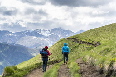 Rückansicht einer Mutter mit männlichem Kind beim Trekking in der Langkofelgruppe, Dolomiten, Trentino-Südtirol, Italien, Europa - RHPLF17943