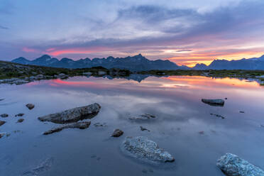 Brennender Himmel bei Sonnenuntergang auf Bergen, die sich im unberührten See spiegeln, Muottas Muragl, Engadin, Kanton Graubünden, Schweiz, Europa - RHPLF17946