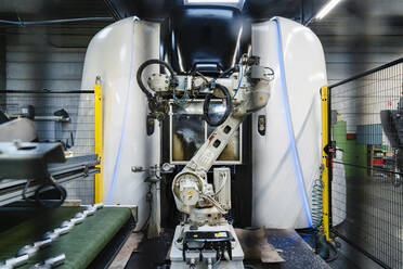 Automatischer Roboterarm gegen Maschinen in der Fertigungsindustrie - DIGF13103