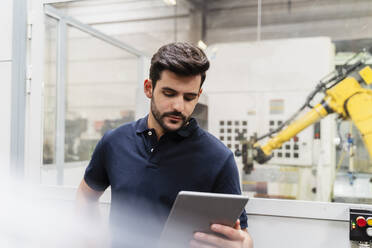 Male worker using digital tablet while standing in manufacturing industry - DIGF13149