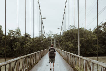 Tourist auf der Fußgängerbrücke über den Fluss Napo, Ecuador - DSIF00193