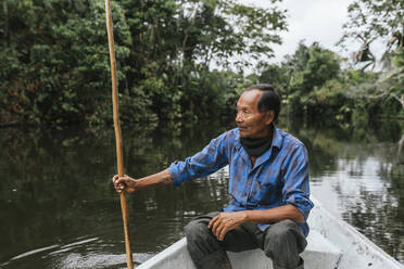 Älterer Guarani-Mann sitzt im Kanu auf dem Napo-Fluss, Ecuador - DSIF00194