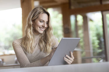 Young woman using digital tablet while sitting at home - PESF02137
