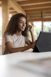 Young businesswoman using digital tablet while sitting at home - PESF02158