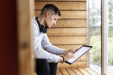 Young man using digital tablet while sitting at home - PESF02205