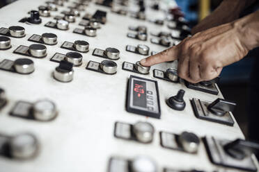 Man's hand operating control panel in factory - GUSF04695