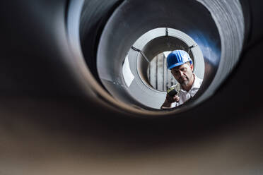 Man scanning barcode on steel rolls in industry - GUSF04796