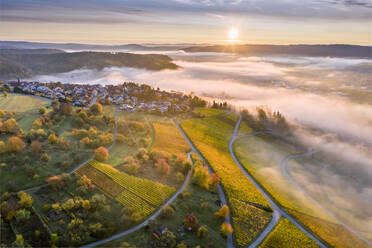 Germany, Baden Wurttemberg, Remstal, Drone view of countryside town at foggy sunrise - STSF02659