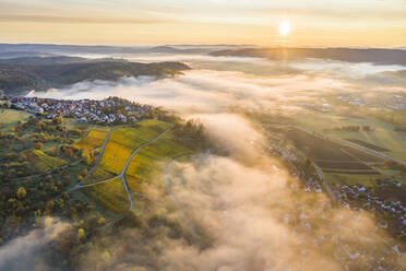 Deutschland, Baden Württemberg, Remstal, Drohnenansicht einer Stadt auf dem Land bei nebligem Sonnenaufgang - STSF02662