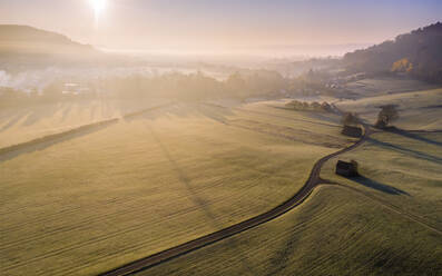 Drone view of countryside fields at foggy autumn sunrise - STSF02674