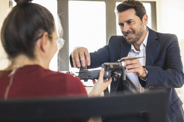 Unternehmer begutachten Quadcopter im Büro - UUF22148