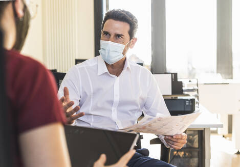 Geschäftsleute mit Gesichtsmaske bei einer Besprechung im Büro - UUF22157