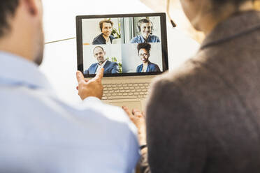 Geschäftsleute, die per Videokonferenz am Laptop im Büro an einer Besprechung teilnehmen - UUF22161