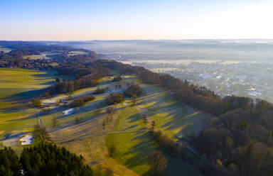 Deutschland, Bayern, Wolfratshausen, Drohnenansicht eines ländlichen Golfplatzes bei nebliger Herbstdämmerung - LHF00828