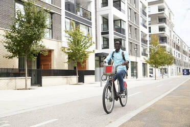 Mature male commuter riding bicycle on street in city - PMF01613