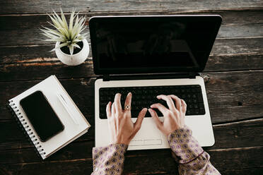 Hands of businesswoman typing on laptop at desk in office - EBBF01564