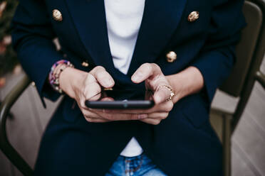 Woman using mobile phone at terrace - EBBF01587