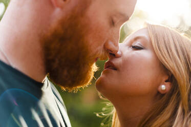 Affectionate heterosexual couple kissing in park - JMPF00669