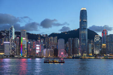 Star Ferry in Victoria Harbour and skyline of Hong Kong Island at dusk, Hong Kong, China, Asia - RHPLF18245