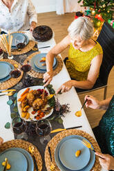 Von oben von Ernte unerkennbar Menschen genießen leckeres Gericht, während am Tisch sitzen während der Weihnachtsferien - ADSF17657