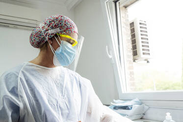 Female dental doctor wearing protective workwear working while standing in clinic during Covid-19 - JCMF01668