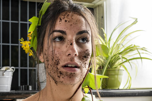 Woman face covered with dirt and leaf at home - GGGF00212