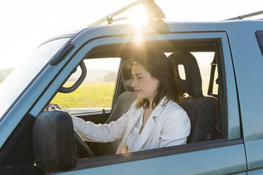 Beautiful woman on road trip driving car during sunset - AFVF07574