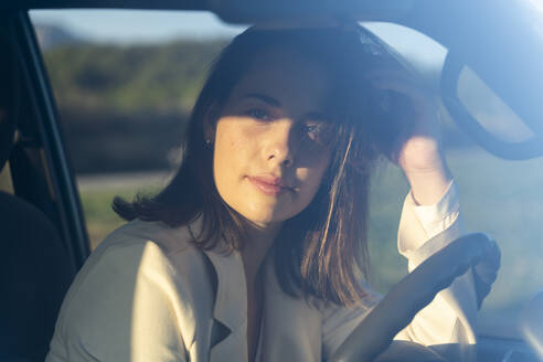 Nachdenkliche Frau im Auto auf einer Reise bei Sonnenuntergang - AFVF07584