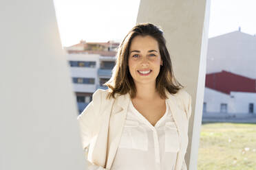 Smiling female entrepreneur in city on sunny day - AFVF07655