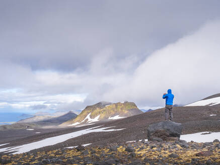 Männlicher Wanderer steht auf einem Felsen im Snaefellsjokull Nationalpark, Island - LAF02604