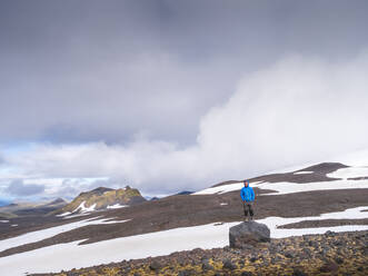 Male hiker standing on top of boulder in Snaefellsjokull National Park, Iceland - LAF02605