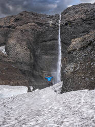 Männlicher Forscher steht auf einem Felsen vor einem Wasserfall in Langjokull, Island - LAF02612