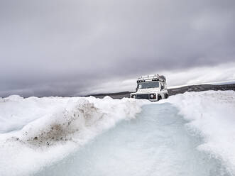 Off road vehicle on snow land against cloudy sky, Langjokull, Iceland - LAF02617