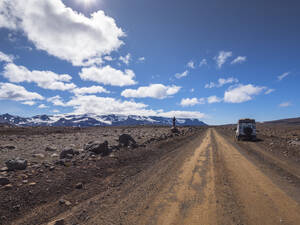 Männlicher Tourist mit Geländewagen auf einem Felsen am Langjokull, Island - LAF02619