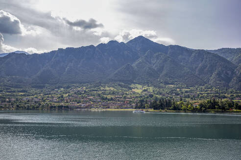 Idyllic view of Lake Idro against mountain ranges and sky - MAMF01420