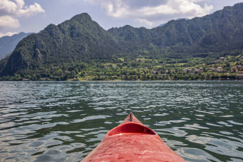 Kayak boat floating on Lake Idro in front of mountains - MAMF01424