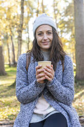 Lächelnde Wanderin mit Teetasse im Wald von Cannock Chase im Winter - WPEF03700