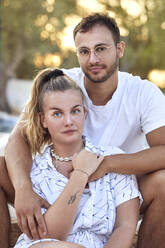 Junges Paar in Freizeitkleidung verbringt seine Freizeit zusammen im Hinterhof am Wochenende - UKOF00087