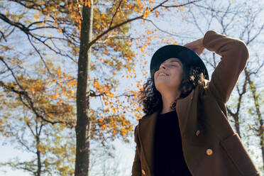 Beautiful woman with eyes closed standing in forest - FMOF01316