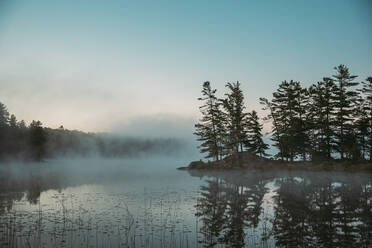 Mist rising off of a lake in the morning in Ontario, Canada. - CAVF90653