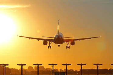 Airplane landing as the sun sets. - CAVF90721