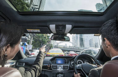 Ein Geschäftspaar fährt zur Hauptverkehrszeit durch Bangkok - CAVF90758